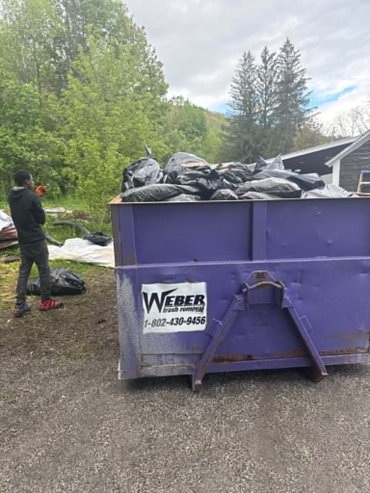 Debris being cleared into a dumpster